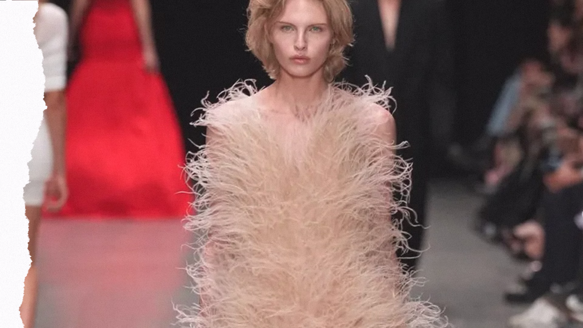 דוגמנית על מסלול התצוגה של סטלה מקרטני לובשת שמלת ערב יוקרתית המעוטרת בשכבות עשירות של נוצות מלאכותיות המשקפת את המעבר של עולם האופנה לטקסטורות עשירות ללא שימוש בפרווה.